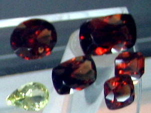 Ceylon Red Zircons and a white zircon with different types of cuts